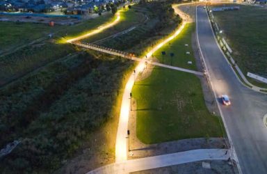An aerial view of Leadsun's solar pathway lights illuminating the Gables Riparian Corridor at dusk.